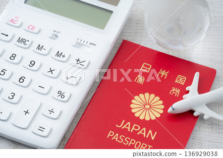 A red Japanese passport and a calculator with a miniature of an airplane and the Earth A red Japanese passport and a calculator with a miniature of an airplane and the Earth 136929038
