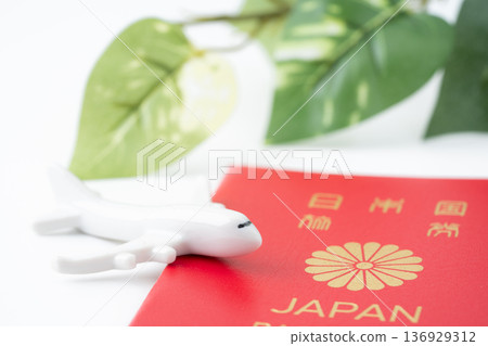 一本紅色的日本護照和一架微型飛機 一本紅色的日本護照和一架微型飛機 136929312