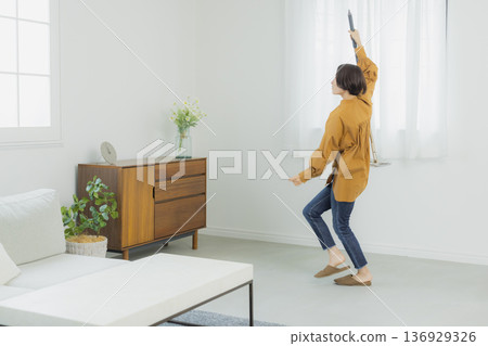 Women listening to music in the living room Women listening to music in the living room 136929326