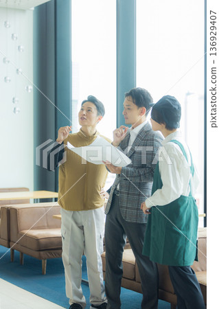 A male craftsman wearing an air-conditioned suit having a meeting while looking at documents A male craftsman wearing an air-conditioned suit having a meeting while looking at documents 136929407