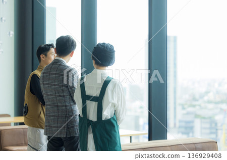 A male craftsman wearing an air-conditioned suit having a meeting while looking at documents A male craftsman wearing an air-conditioned suit having a meeting while looking at documents 136929408