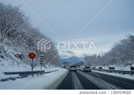 A view of a highway running through snowy mountainous areas A view of a highway running through snowy mountainous areas 136929680