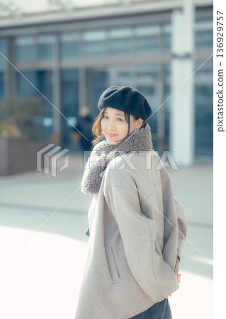 一位女子漫步在冬日的城市中,回頭望去。 一位女子漫步在冬日的城市中,回頭望去。 136929757