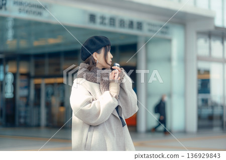 冬天,一位女士在戶外等候時正在查看智慧型手機。 冬天,一位女士在戶外等候時正在查看智慧型手機。 136929843