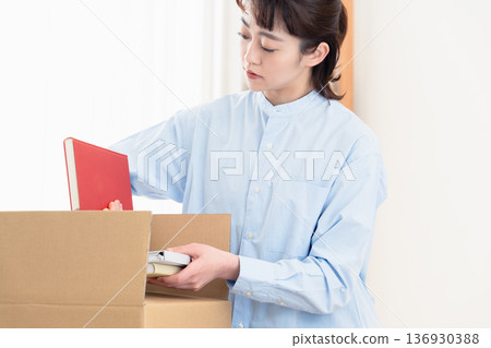 一個女孩在整理她的書 136930388