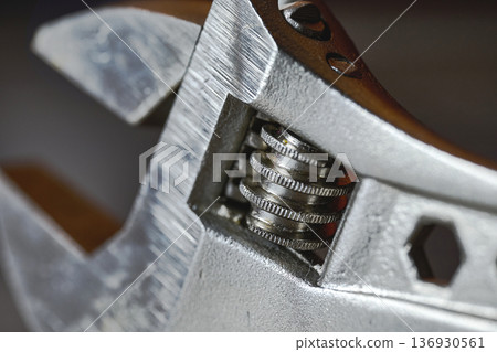 Detailed macro view of an adjustable wrench head showing the screw mechanism and metal texture 136930561