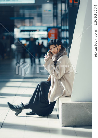 A woman waiting at a station in winter A woman waiting at a station in winter 136930574