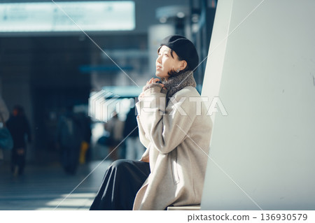 A woman waiting at a station in winter 136930579