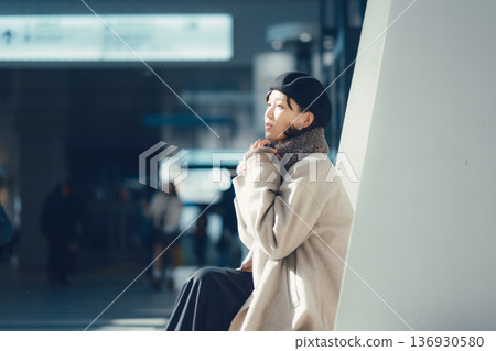 A woman waiting at a station in winter A woman waiting at a station in winter 136930580