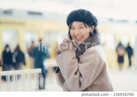A woman in her 30s drinking coffee while walking inside the station A woman in her 30s drinking coffee while walking inside the station 136930706