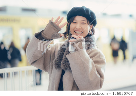 A woman in her 30s drinking coffee while walking inside the station A woman in her 30s drinking coffee while walking inside the station 136930707