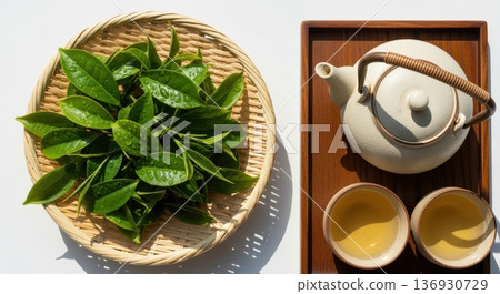 Image of Japanese tea with tea fields under blue sky, freshly picked tea leaves, teapot and teacups 136930729