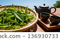 Image of Japanese tea with tea fields under blue sky, freshly picked tea leaves, teapot and teacups 136930733