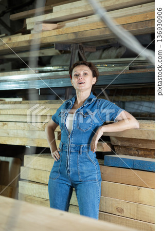 Portrait of positive female lumber warehouse worker 136930906