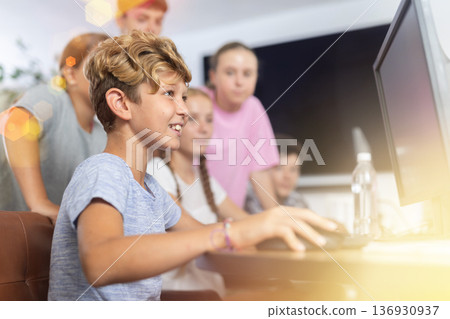 Preteen boy working with computer programs in training room Preteen boy working with computer programs in training room 136930937