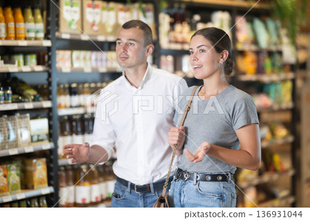Couple exploring with interest shelves at organic foods store Couple exploring with interest shelves at organic foods store 136931044