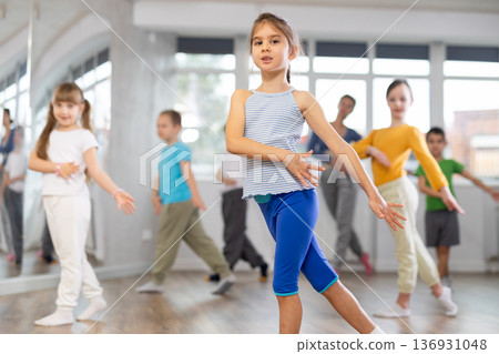 Girl learn to dance modern dances, doing movement with unrecognizable teacher. Girl learn to dance modern dances, doing movement with unrecognizable teacher. 136931048