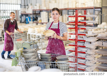 Young woman posing with ceramic dishes Young woman posing with ceramic dishes 136931057