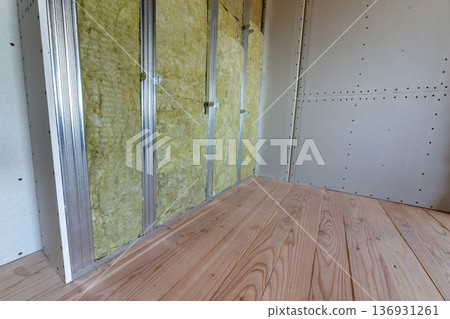 Wall of a room under renovation with mineral rock wool insulation and metal frame prepared for drywall plates. Wall of a room under renovation with mineral rock wool insulation and metal frame prepared for drywall plates. 136931261