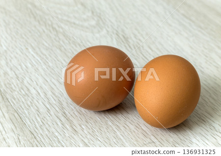 Hen eggs on kitchen table background. Healthy organic food, delicious meal, cholesterol and diet concept. Hen eggs on kitchen table background. Healthy organic food, delicious meal, cholesterol and diet concept. 136931325
