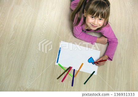 Child girl drawing with colorful pencils crayons heart on white paper. Art education, creativity concept. 136931333