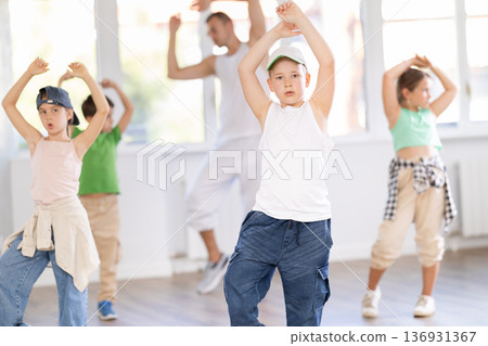 Preteen boy honing hip hop dance moves in choreographic studio Preteen boy honing hip hop dance moves in choreographic studio 136931367