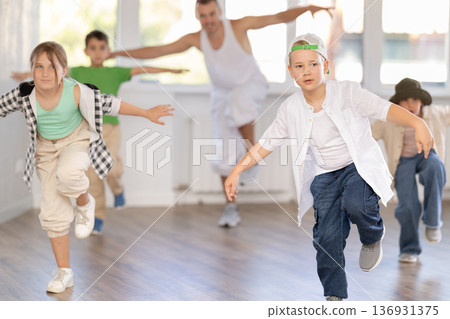 Emotional happy teen boy dancing hip hop with group of friends in dance studio. Concept hip-hop generation 136931375