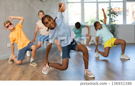 African boy perform choreographic exercises and teach energetic social dance hip hop with friends African boy perform choreographic exercises and teach energetic social dance hip hop with friends 136931386