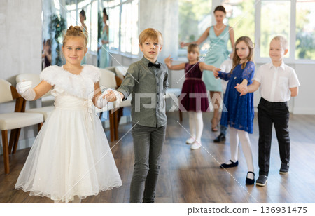 Preteen pupils rehearsing ballroom dance for festive school event Preteen pupils rehearsing ballroom dance for festive school event 136931475