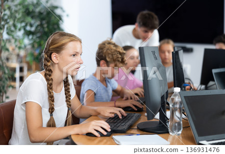 Girl student learning to work on computer in classroom 136931476