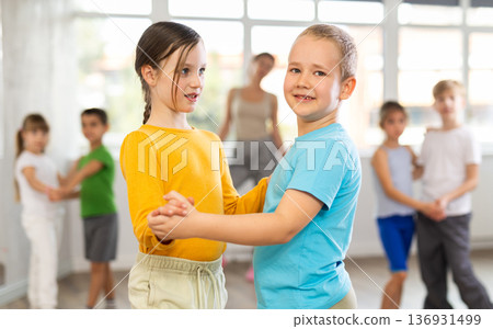 Girl paired up with boy and training to perform slow couple dance, rehearse performance. 136931499