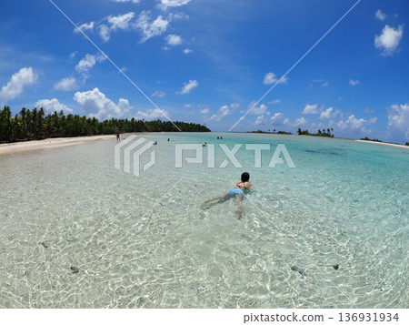 A woman playing in the shallow lagoon and white sand beach of Fakarava, Tahiti | Crystal clear waters of a tropical paradise A woman playing in the shallow lagoon and white sand beach of Fakarava, Tahiti | Crystal clear waters of a tropical paradise 136931934