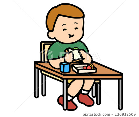 午餐時間:一個棕髮男孩在辦公桌前吃三明治。 午餐時間:一個棕髮男孩在辦公桌前吃三明治。 136932509