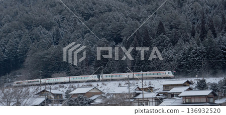 特快列車飛驒(HC85系列)在白雪皚皚的景色中駛過宮殿市的大彎道。 特快列車飛驒(HC85系列)在白雪皚皚的景色中駛過宮殿市的大彎道。 136932520