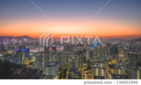 Jan 11 2026 Kowloon skyline illuminated under vibrant orange twilight sky 136932999