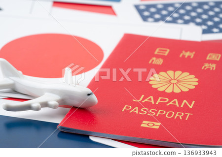 一張卡片上印有紅色的日本護照、一架微型飛機以及各種國家的國旗。 一張卡片上印有紅色的日本護照、一架微型飛機以及各種國家的國旗。 136933943