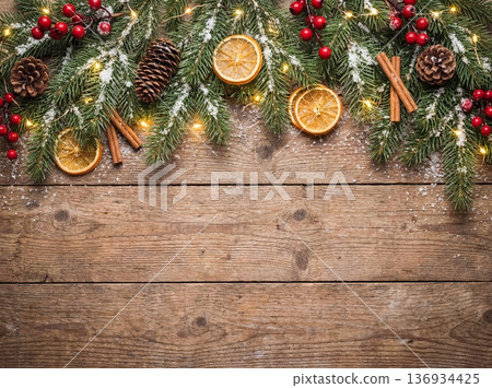 Christmas wooden background with fir branches red berries and dried oranges 136934425