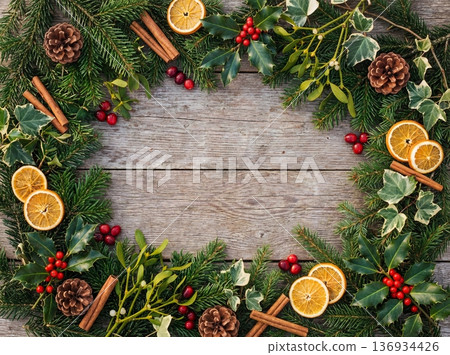 Christmas decorative border with pine branches dried oranges and spices on rustic wood 136934426