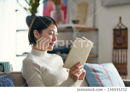 A woman reading in the living room A woman reading in the living room 136935252