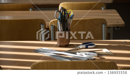 Classroom Desk With Stationery Items under Natural Light Classroom Desk With Stationery Items under Natural Light 136935558