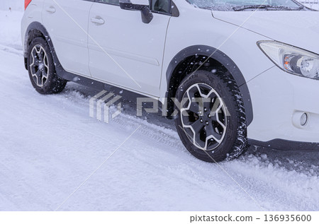 An SUV with all-season tires driving through a snowstorm-prone area 136935600