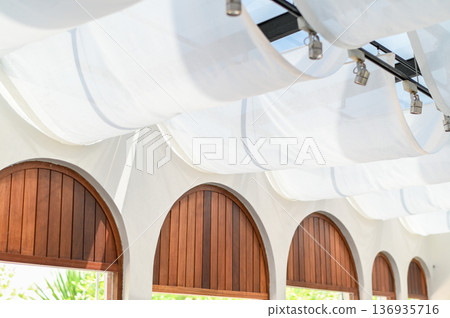 White fabric canopy ceiling light modern interior arched window wooden shutter natural light minimalist design bright architecture summer atmosphere resort style indoor shade canopy White fabric canopy ceiling light modern interior arched window wooden shutter natural light minimalist design bright architecture summer atmosphere resort style indoor shade canopy 136935716