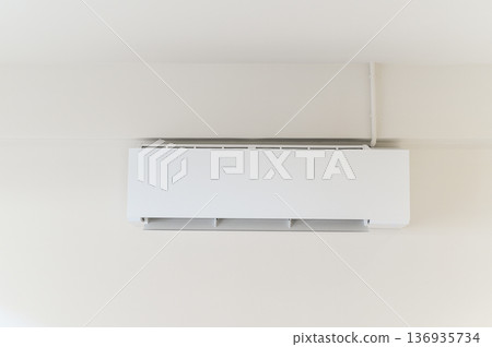 White wall mounted air conditioner modern climate control device energy efficient cooling minimalist interior clean home appliance comfortable temperature quiet operation summer comfort 136935734