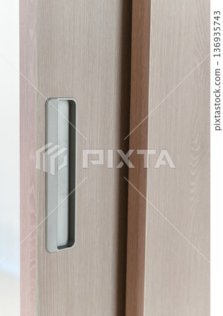 Sliding door wooden surface recessed handle modern style light brown color minimalist design interior vertical lines smooth texture home decor contemporary look 136935743