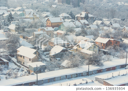Winter in the city. Snow on rooftop. Winter Kyiv landmark. Frosty winter weather. Snowfall in downtown district. Snow and wind. Buildings and street covered with snow on sunny day 136935934