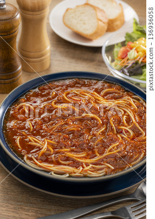 午餐場景，桌上放著一大碗肉醬義大利麵。 136936058