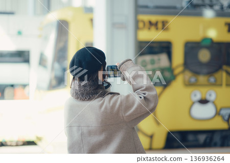 一名女子在車站內用智慧型手機拍照。 136936264