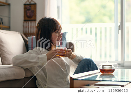 A woman relaxing in the living room 136936613