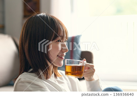 A woman relaxing in the living room 136936640