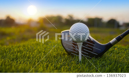 Golf clubs and balls on a green lawn in a beautiful golf course with morning sunshine. 136937023